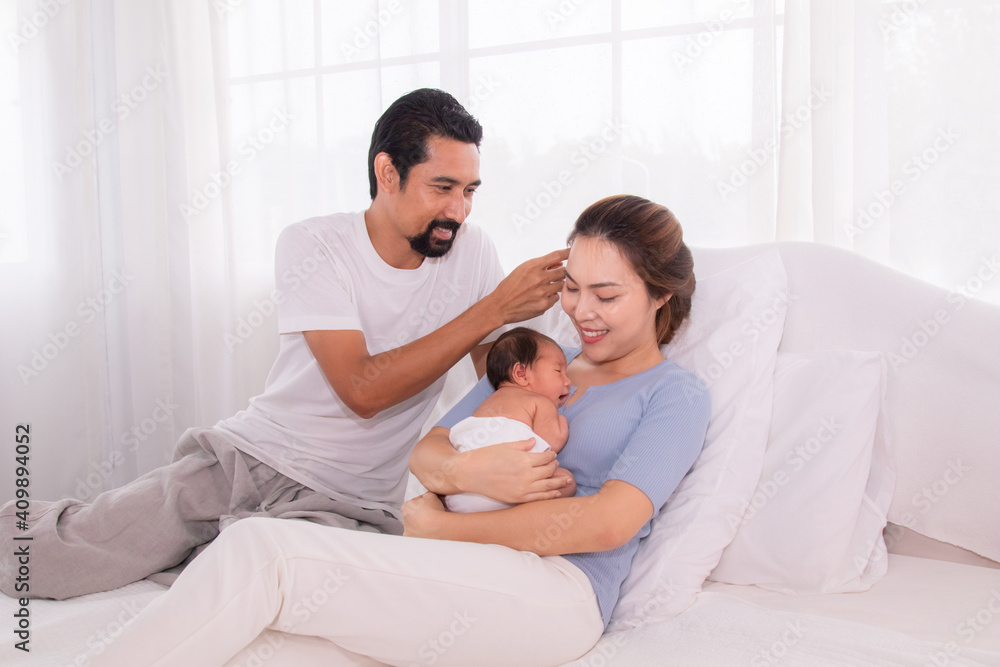 Hand of father clear sweat of beautiful mother while embrace hold newborn infant, mom and dad help raising first child son together, wife get fatigue feeding her baby, beginner family concept Hand of father clear sweat of beautiful mother while embrace hold newborn infant, mom and dad help raising first child son together, wife get fatigue feeding her baby, beginner family concept