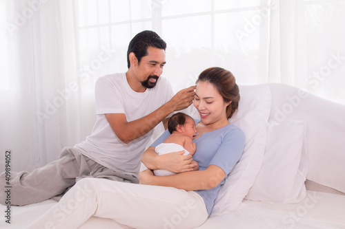 Hand of father clear sweat of beautiful mother while embrace hold newborn infant, mom and dad help raising first child son together, wife get fatigue feeding her baby, beginner family concept