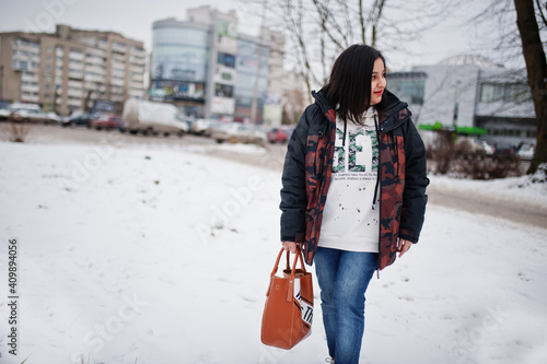 Yong asian woman wear jacket with handbag in cold winter day.