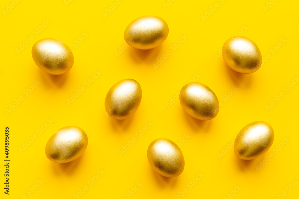 Golden eggs on yellow. Easter decoration background. Top view Golden eggs on yellow. Easter decoration background. Top view
