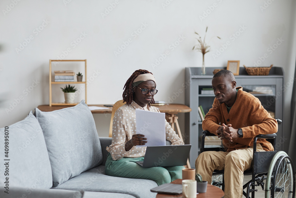 Portrait of African-American couple with handicapped man working from home together in modern interior, copy space - obrazy, fototapety, plakaty 