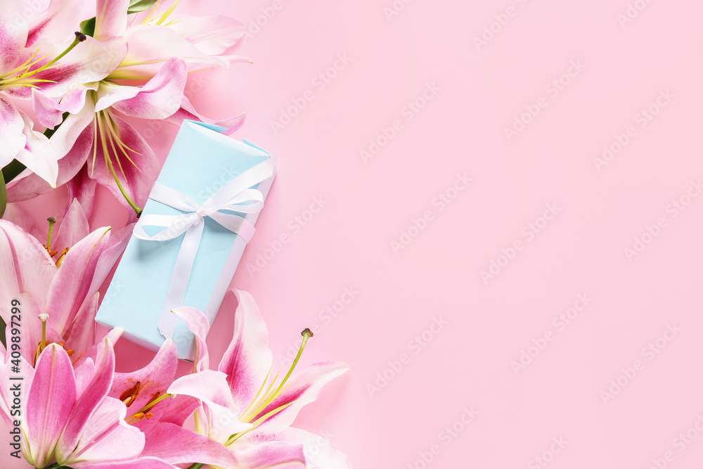 Beautiful lilies and gift on color background Beautiful lilies and gift on color background