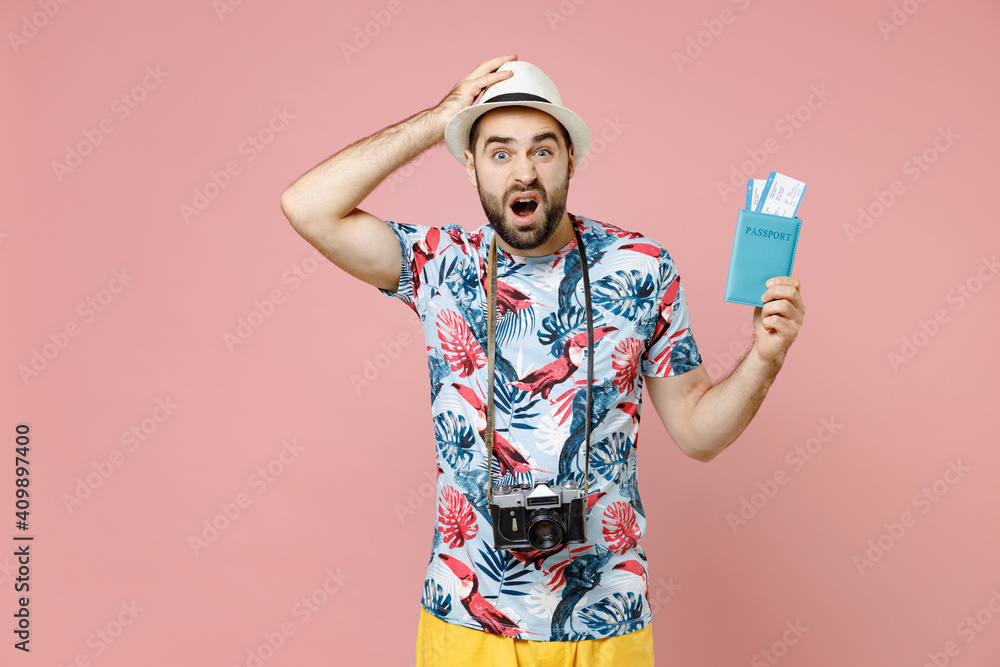 Worried young traveler tourist man in summer clothes hat hold passport tickets boarding pass put hand on head isolated on pink background. Passenger traveling on weekends. Air flight journey concept. Worried young traveler tourist man in summer clothes hat hold passport tickets boarding pass put hand on head isolated on pink background. Passenger traveling on weekends. Air flight journey concept.