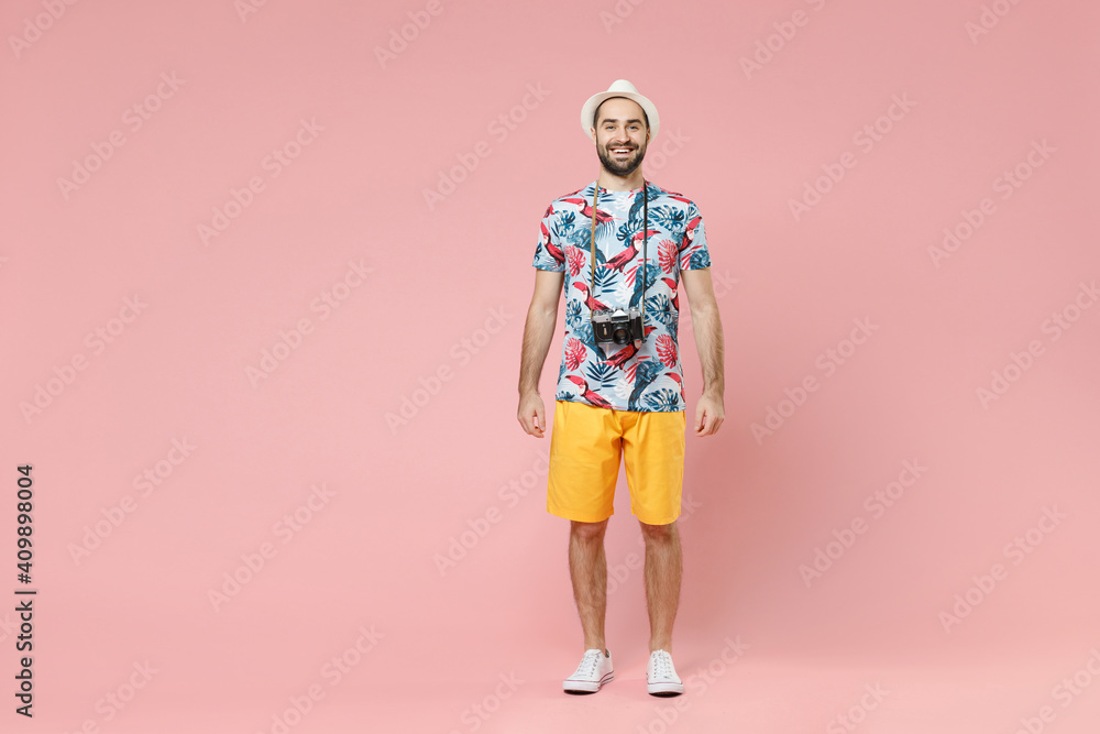 Full length of smiling young traveler tourist man in summer clothes hat with photo camera isolated on pink background studio portrait. Passenger traveling on weekends. Air flight journey concept. Full length of smiling young traveler tourist man in summer clothes hat with photo camera isolated on pink background studio portrait. Passenger traveling on weekends. Air flight journey concept.