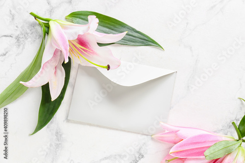 Fototapeta Naklejka Na Ścianę i Meble -  Beautiful lilies and envelope on light background
