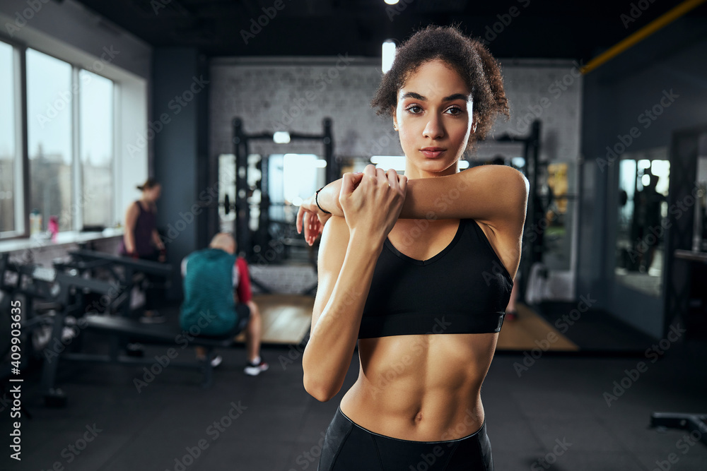 Young sporty female preparing for lifting dumbbells Young sporty female preparing for lifting dumbbells