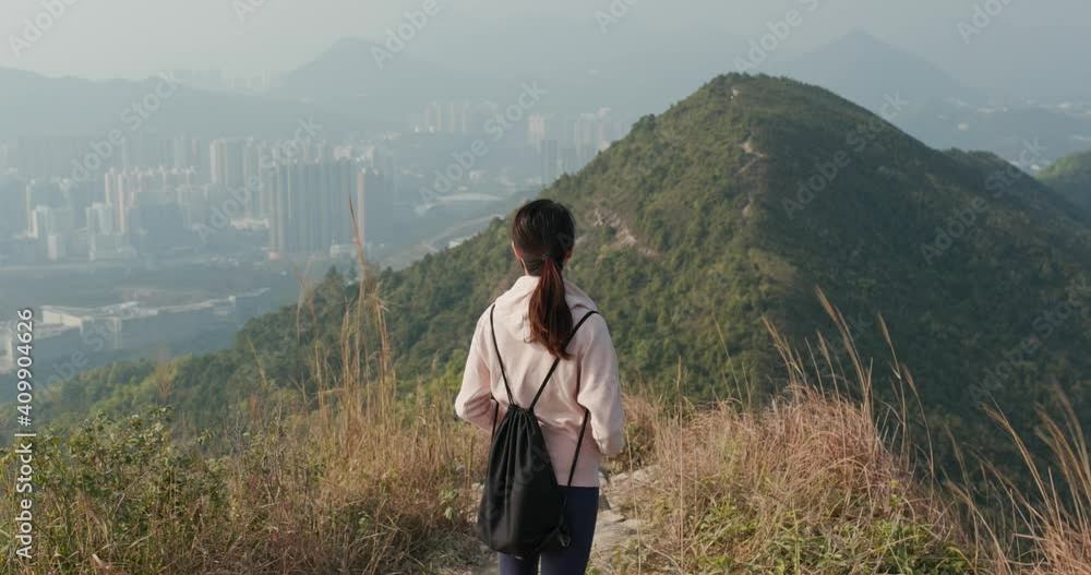 Woman look at the top of the mountain and prepare to hike Woman look at the top of the mountain and prepare to hike