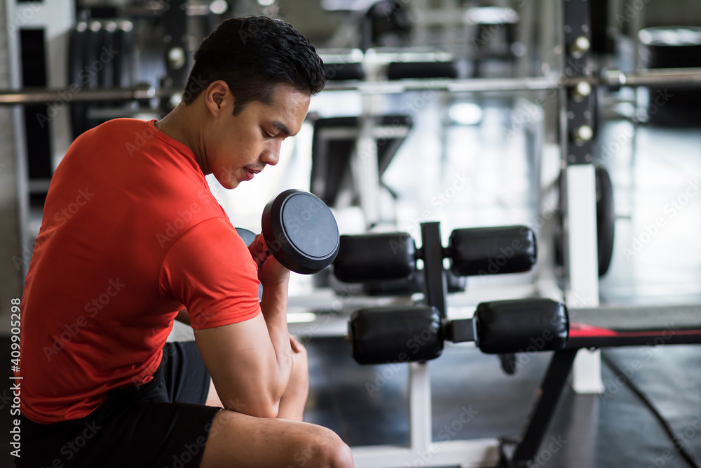 Young fit Asian man exercise dumbbell in gym Young fit Asian man exercise dumbbell in gym