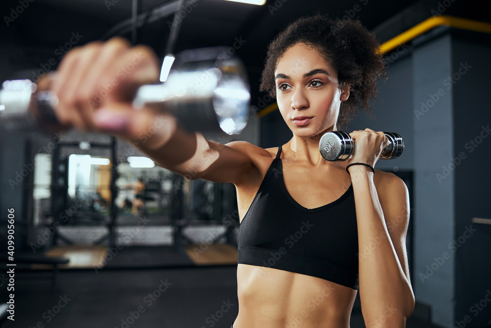 Active female person lifting heavy metal dumbbells Active female person lifting heavy metal dumbbells