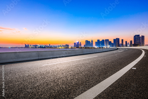 Empty asphalt road and modern city skyline in Hangzhou at sunrise China.