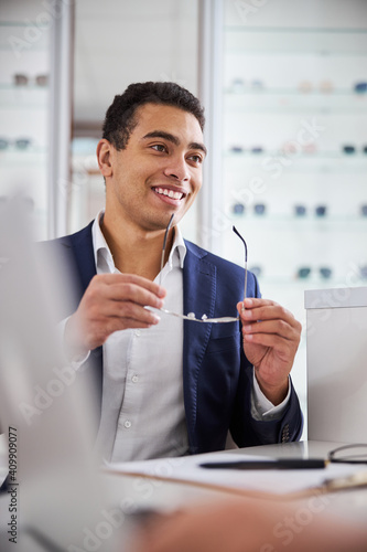 Man holding prescription spectacles in his hands photo