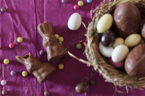 Top view of chocolate bunnies and nest with easter eggs