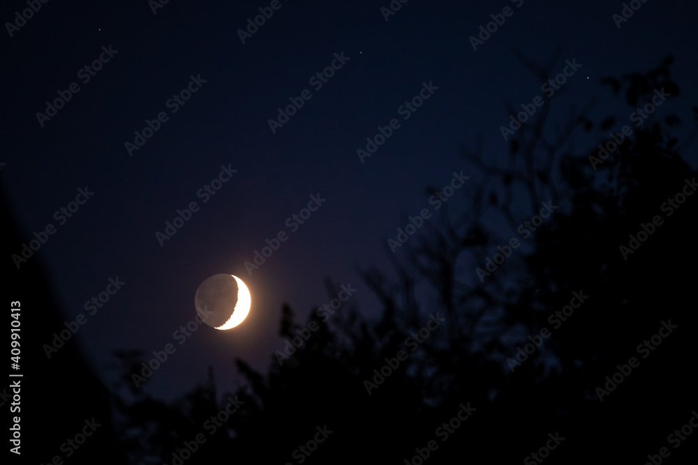 young crescent moon with the dark side in sight 