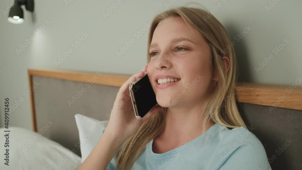 A beautiful woman is talking on the phone lying in the bedroom A beautiful woman is talking on the phone lying in the bedroom