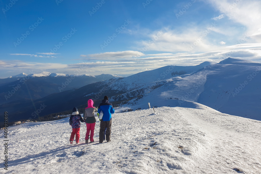 People observing mountain scenery. Family of three people stays in front of scenic landscape.