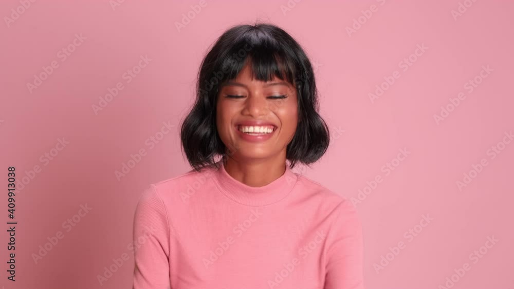 Young positive dark skinned young woman looks up crossing her fingers and hopes for good luck cheerful female posing on pink background. Concept of luck hope dreams and victory. Young positive dark skinned young woman looks up crossing her fingers and hopes for good luck cheerful female posing on pink background. Concept of luck hope dreams and victory.