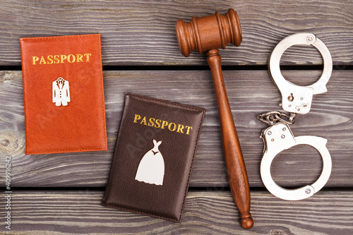 Domestic voilence and trial concept. Married cople passports with gavel and handcuffs. photo