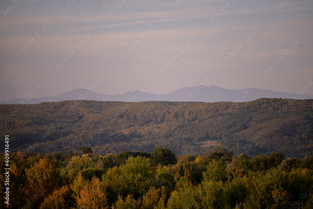 autumn landscape overlooking the horizon where the ridges of the high mountains can be seen. high hills full of dense forests
