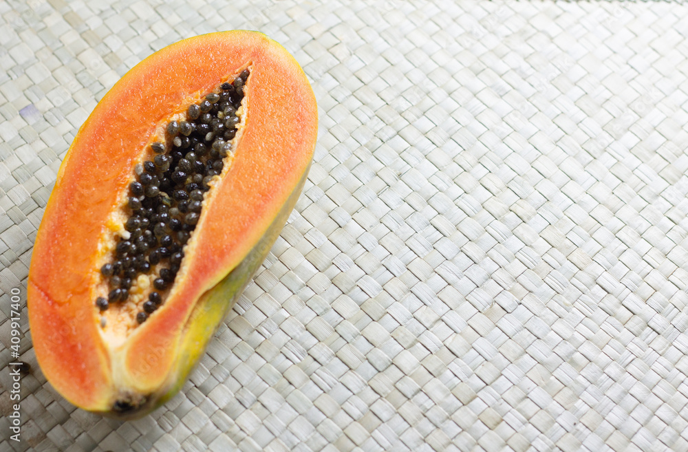 Pepaya or ripe papaya fruit one of tropical fruit in Indonesia. Cut into pieces on woven matt background. Close up view, copy space for text. Pepaya or ripe papaya fruit one of tropical fruit in Indonesia. Cut into pieces on woven matt background. Close up view, copy space for text.