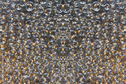 A pattern of white-brown rings and brown-gold spheres of various diameters is symmetrically located on a brown background. Abstract fantasy.