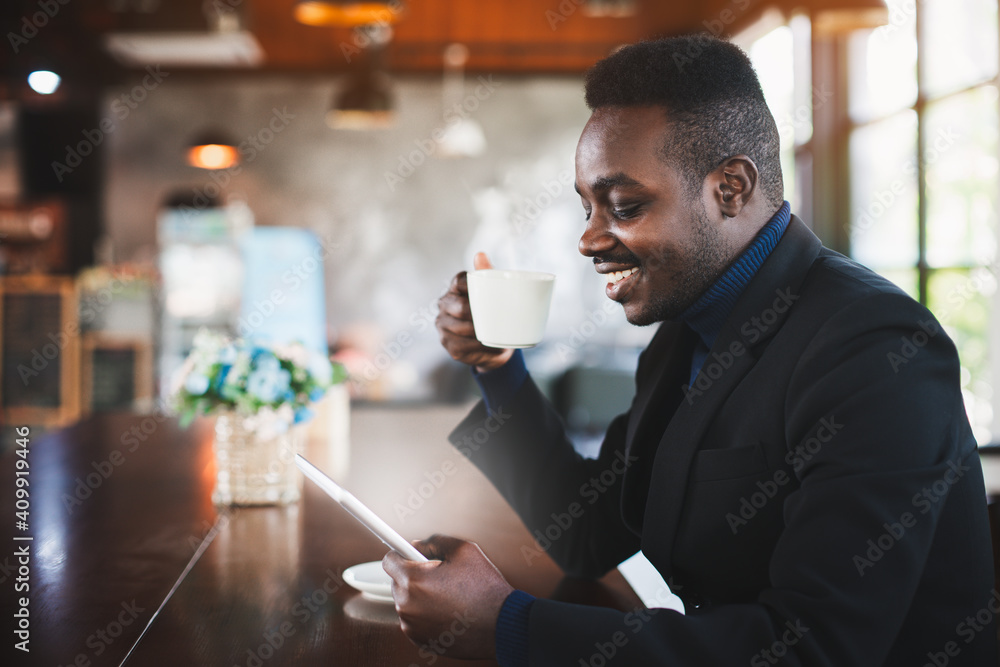 African businessman using tablet computer in coffee shop