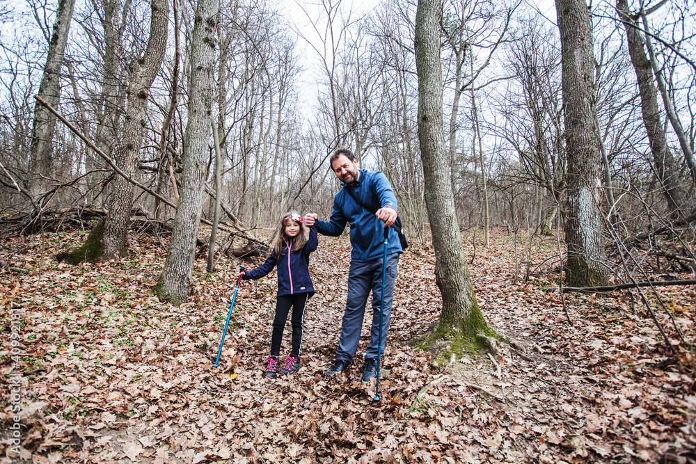 Happy family portrait of father and daughter hiking through forest on daylight. Happy family portrait of father and daughter hiking through forest on daylight.
