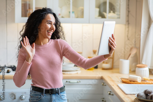 Joyful Brunette Lady Making Video Call With Digital Tablet In Kitchen