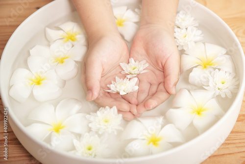 Spa treatment and product for female feet and hand spa. white flowers in ceramic bowl with water for aroma therapy at spa.