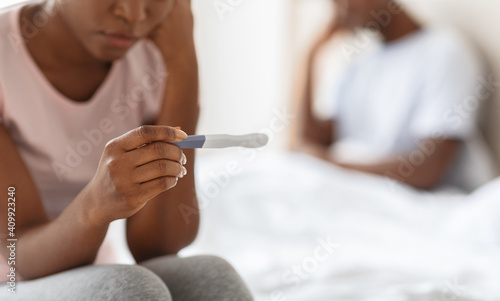 Unrecognizable black woman holding pregnancy test, unintended pregnancy concept