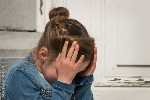 Image of a young exasperated girl with her head in her hands. photo