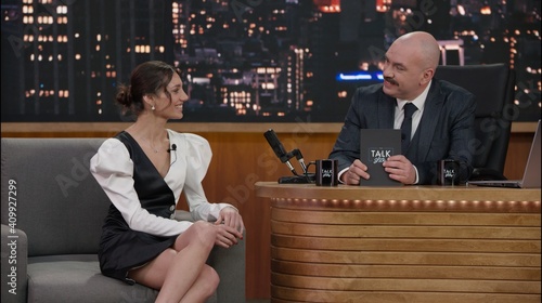 Foto Late-night talk show host having a conversation with celebrity guest in a studio