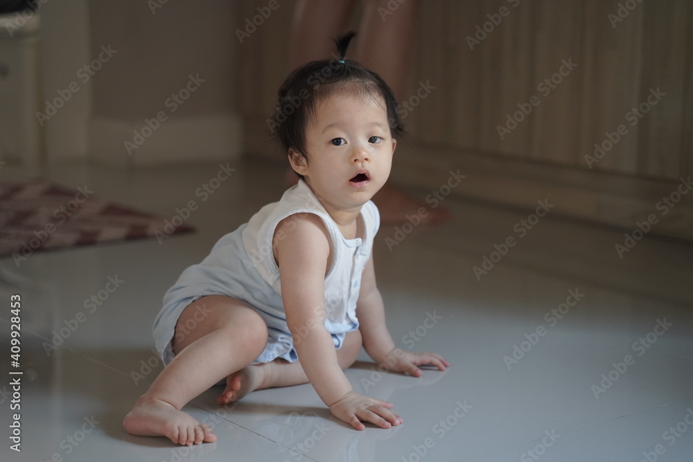 Baby girl is crawling in her house on the floor.Baby is learning how to crawl during waiting her mother .Asian baby girl is ten months old. Baby girl is crawling in her house on the floor.Baby is learning how to crawl during waiting her mother .Asian baby girl is ten months old.