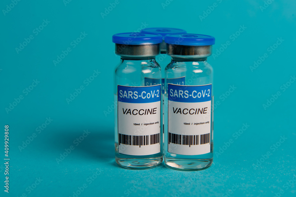 Covid-19 coronavirus vaccine bottle on blue background. Selective focus. Covid-19 coronavirus vaccine bottle on blue background. Selective focus.