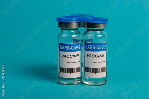 Covid-19 coronavirus vaccine bottle on blue background. Selective focus.