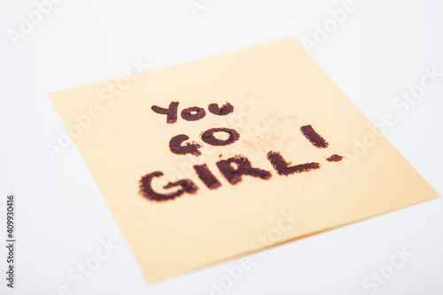 Empowering women feminist note on yellow paper saying you go girl