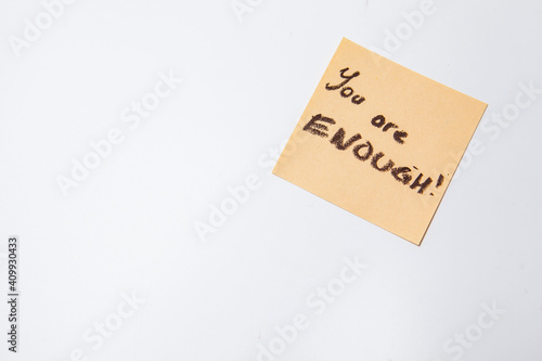 You are enough text written on yellow sticky note