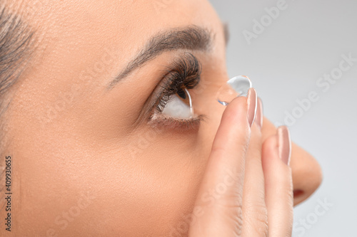 One woman holds contact lens on her finger. Eye care and the choice between the means to improve vision.