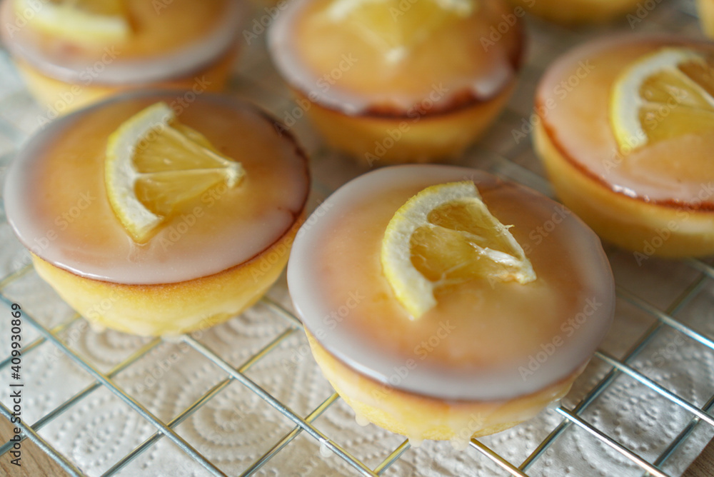 Moist and Sweet Lemon Butter Cake flavored with Lemon Juice Glaze Icing and Zest, garnished with a lemon slice. Soft and Sour Cream Lemon Dessert, putting on a steel baking rack.