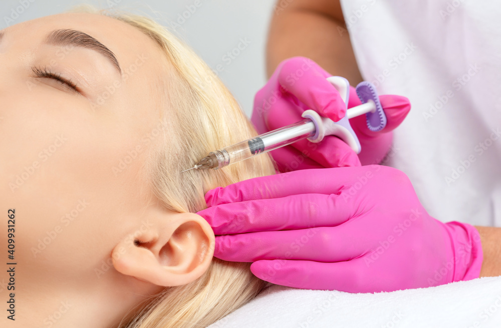 Cosmetologist does injections therapy against hair loss and anti-dandruff of a beautiful woman in a beauty salon. Cosmetology concept. Cosmetologist does injections therapy against hair loss and anti-dandruff of a beautiful woman in a beauty salon. Cosmetology concept.