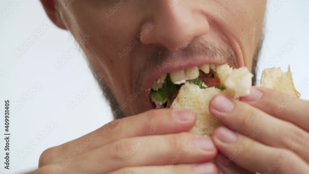 Close up view of male mouth isolated on white background. Young serious handsome half naked Caucasian man with thick dark brown beard, moustache eagerly eat with pleasure fresh fish tasty sandwich. Close up view of male mouth isolated on white background. Young serious handsome half naked Caucasian man with thick dark brown beard, moustache eagerly eat with pleasure fresh fish tasty sandwich.