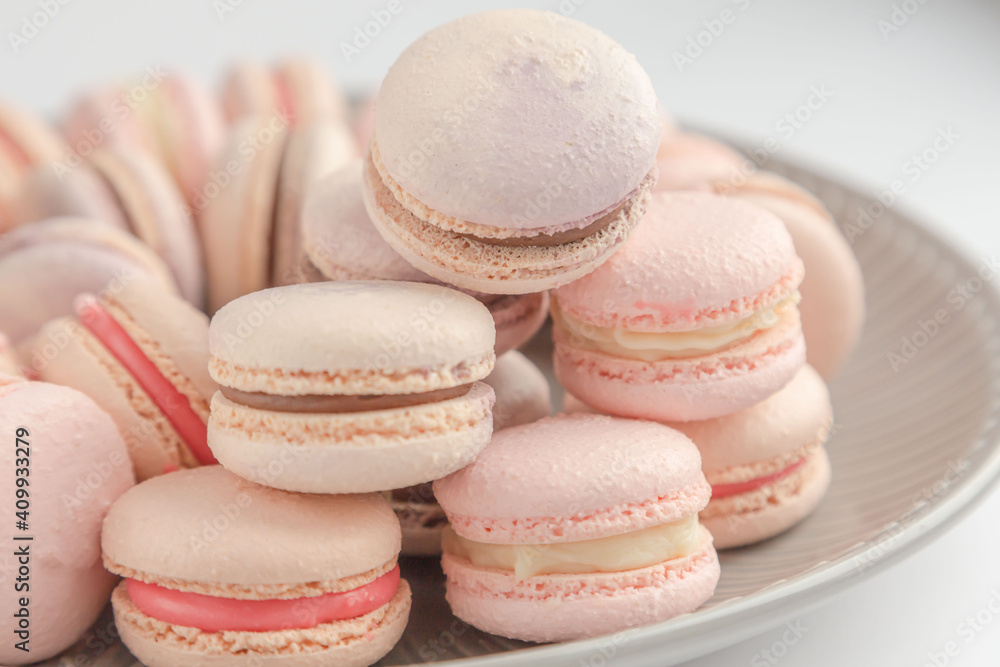 Lots of delicate French macarons lie on a gray, vintage platter. Vintage. Advertising. Desser. Postcard. Place for an inscription. View from above. Dessert with tea. Confectioner. Cream. France.