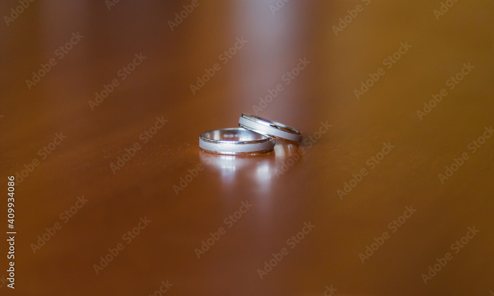 shiny silver wedding rings on wooden table shiny silver wedding rings on wooden table