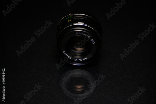 Lens from the USSR on a black background and glass