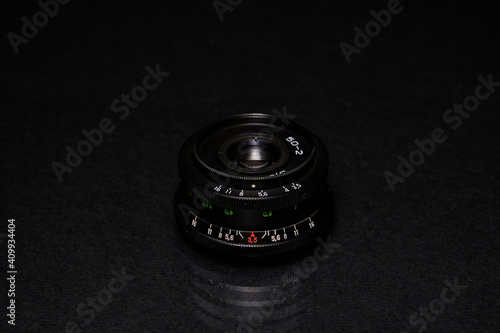 Lens from the USSR on a black background and glass