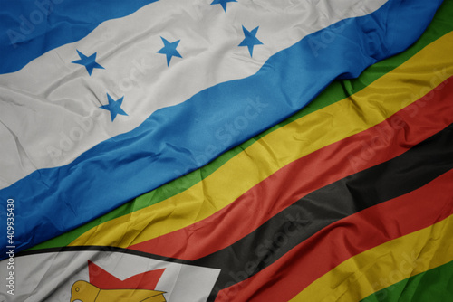 waving colorful flag of zimbabwe and national flag of honduras.