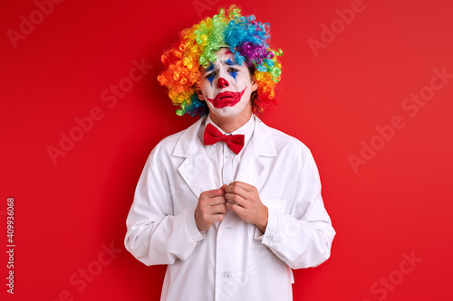 Fotografija sad clown stand depressed having painted face make-up, crying during performance