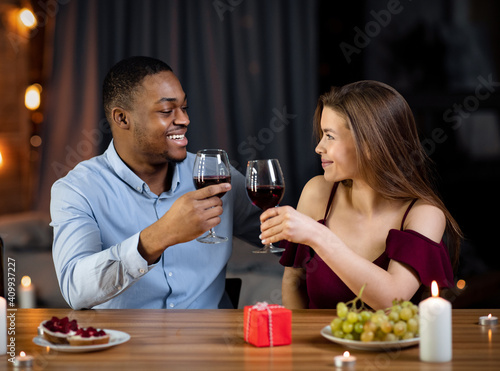 Affectionate Mixed Couple Having Romantic Dinner In Restaurant, Drinking Wine And Smiling