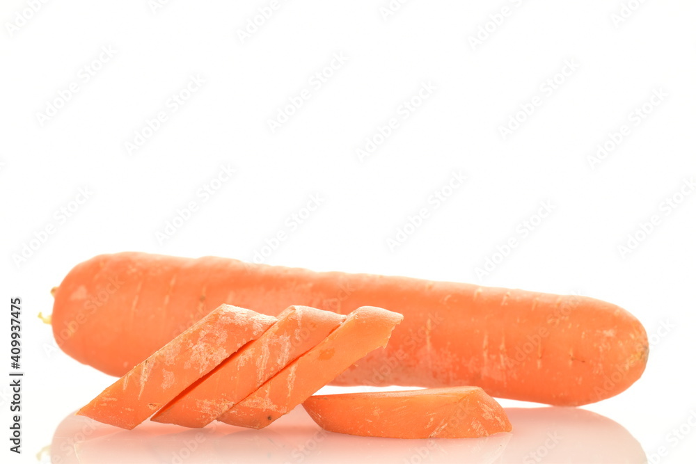 Several slices of fresh organic, unpeeled carrots in the foreground, in focus. In the background is one carrot. The background is white.