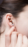 Woman's hand straightens an earring