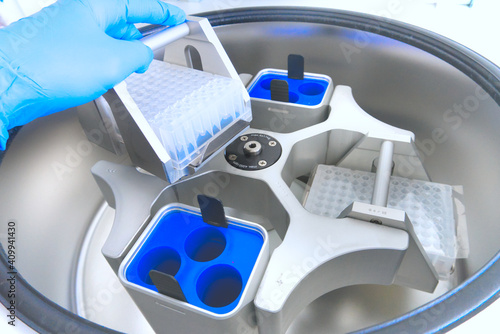 Obraz na płótnie scientist puts the test tubes in centrifuge. Automation in the clinical laboratory. Pipetting robot laboratory. Research and science background w salonie